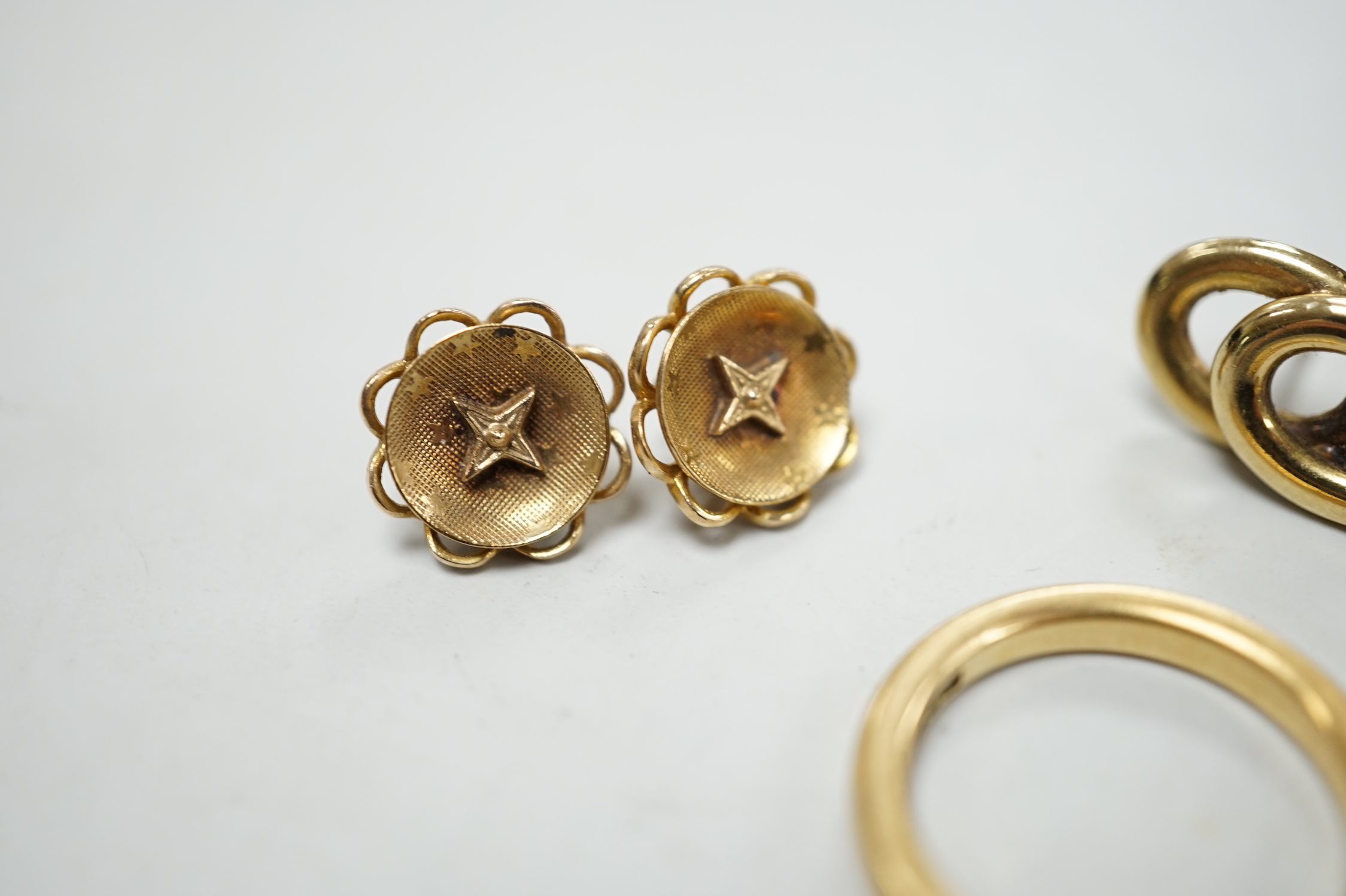 An 18ct gold wedding band, size L/M, 5.2 grams and three pairs of yellow metal earrings.